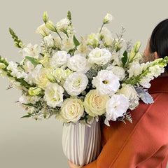 Bundle of Vendela Roses, Alstroemeria Whistler, Caspia, White Lisianthus, White Aster, Bupleurum and snapdragons with Dusty Miller greeneries.