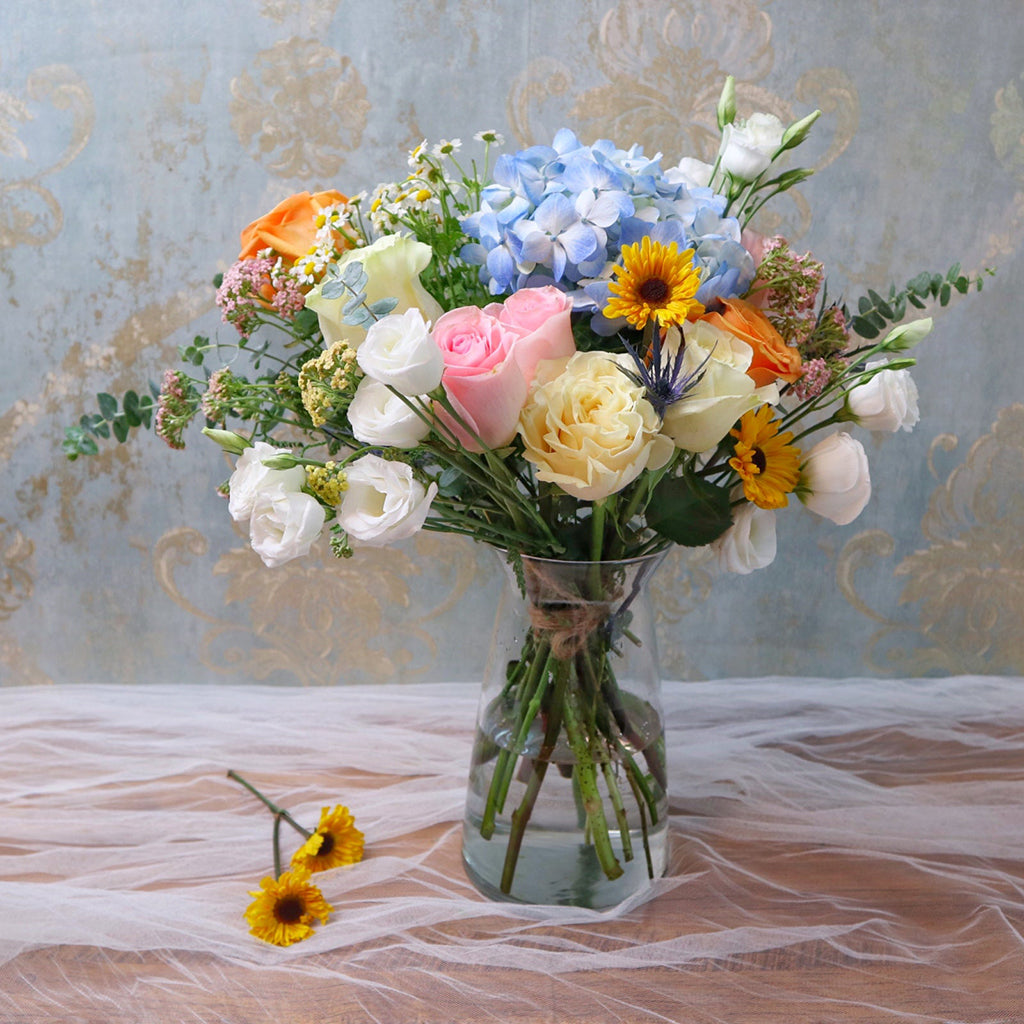 Bundle of Roses, Lisianthus, Pomp Daisies, and Blue Hydrangeas with Eucalyptus greeneries.