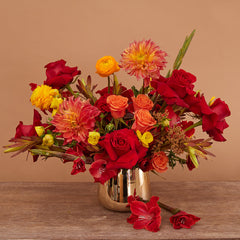 Bouquet of Freedom Roses, Orange Ranunculus, Yellow Ranunculus, Orange Spray Roses, Orange Dahlia, Red Gladiolus, Leucadendron, and Celosia.
